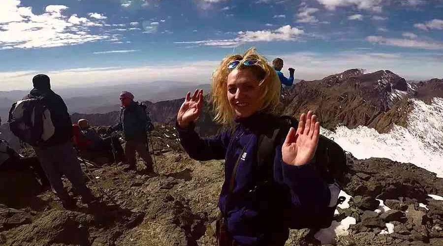 Joyful hiker waving on the 2-Day Mount Toubkal Trek route.