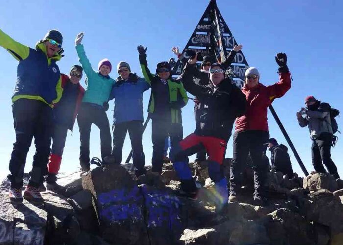 Joyful group on Mount Toubkal summit during a 4-Day Mount Toubkal Trek.