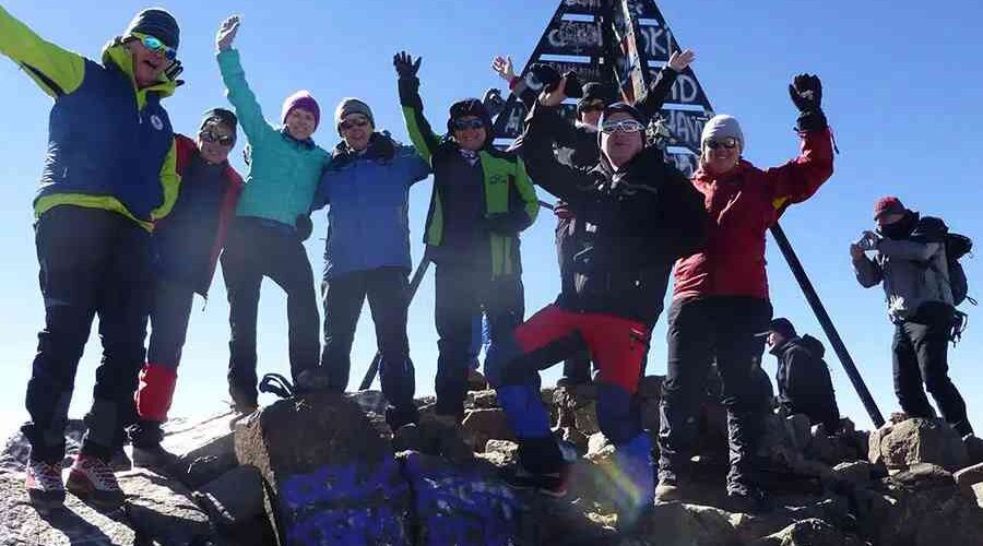 Joyful group on Mount Toubkal summit during a 4-Day Mount Toubkal Trek.