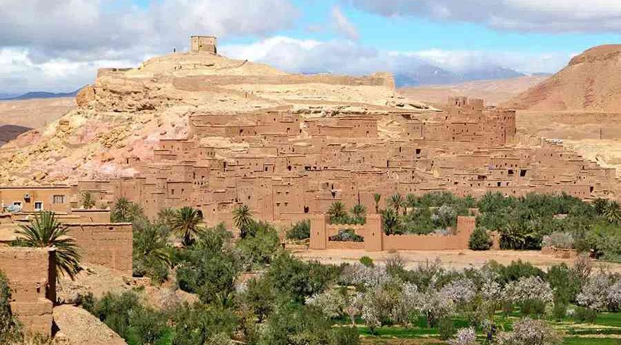 Kasbah Ait Ben Haddou overlooking lush green oasis in Morocco.