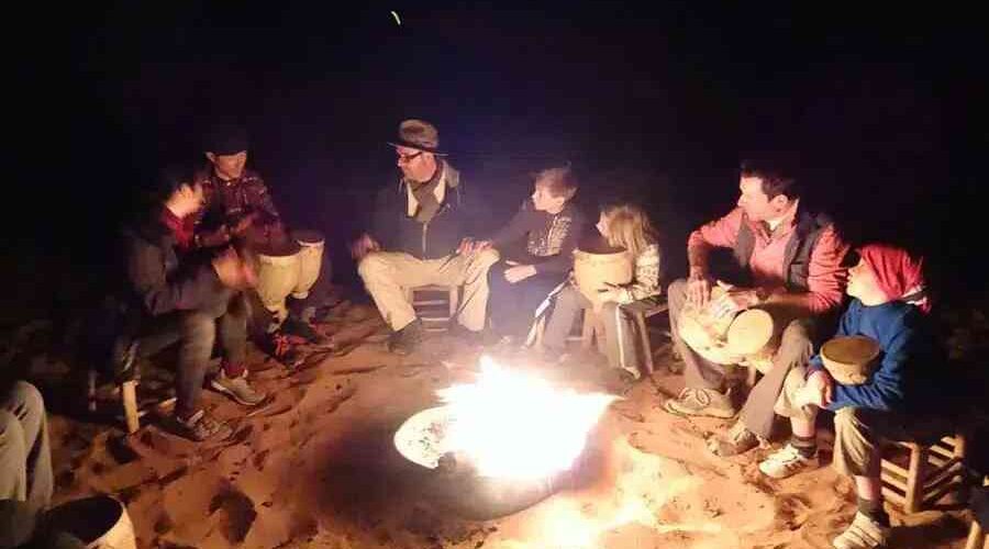 guests around the Merzouga camp bonfire listening to noamads stories while on their Marrakech to Fes group tour