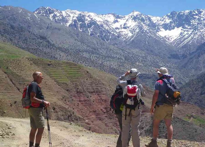 Trekkers observing snow-capped peaks during the Imlil to Ourika Valley 3-day trek in the Atlas Mountains.