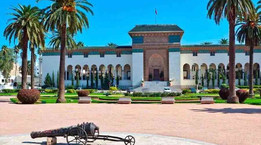 The Royal Palace of Casablanca, a stately building surrounded by palm trees, under the clear blue sky, seen on cultural tours from Marrakech.