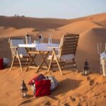 Intimate desert dining on sandy dunes during a private 3-day Marrakech to Merzouga tour.