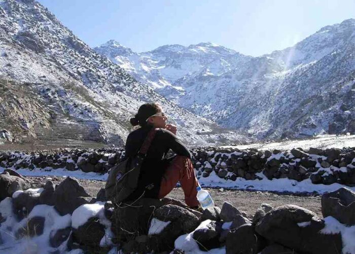 Adventurer pausing on a snowy trek during a 3-day Mount Toubkal ascent.