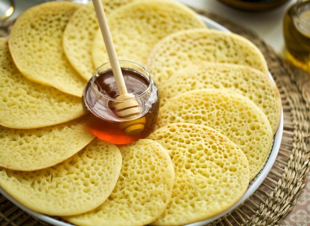 Moroccan Baghrir pancakes with distinctive holes served with honey.
