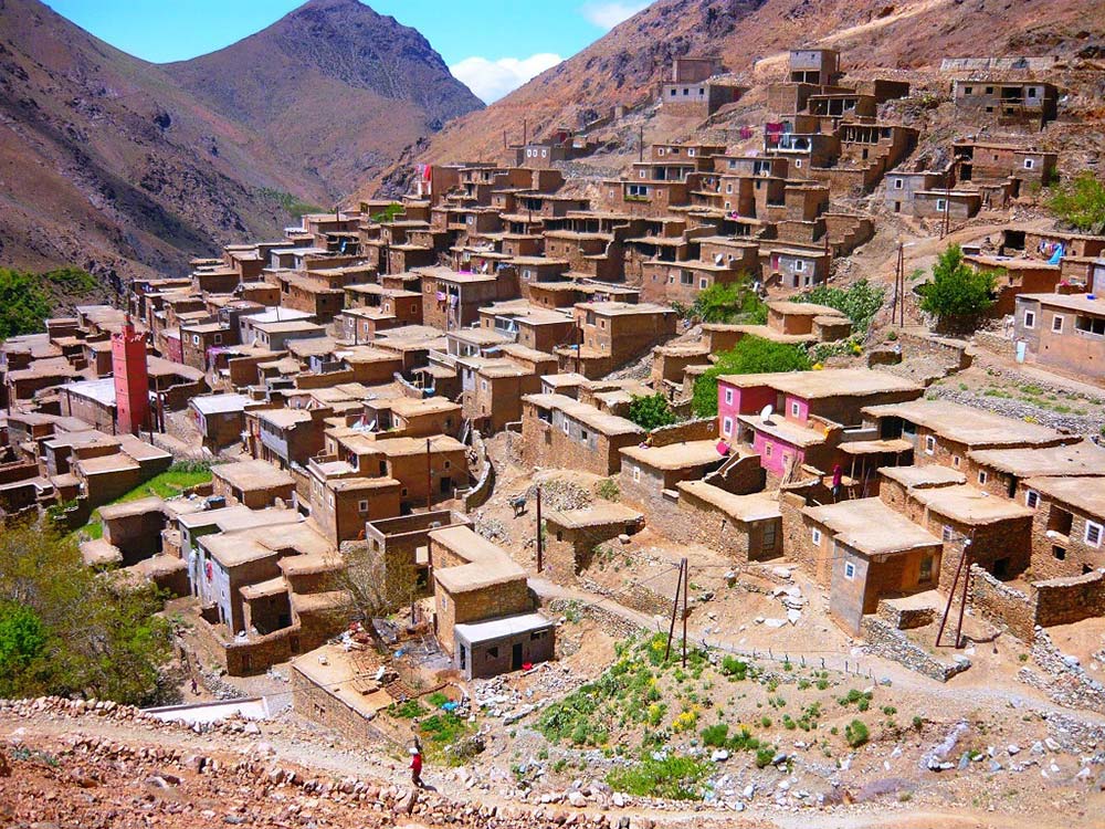 Terraced clay houses of a traditional Berber village nestled on the slopes of the Atlas Mountains.