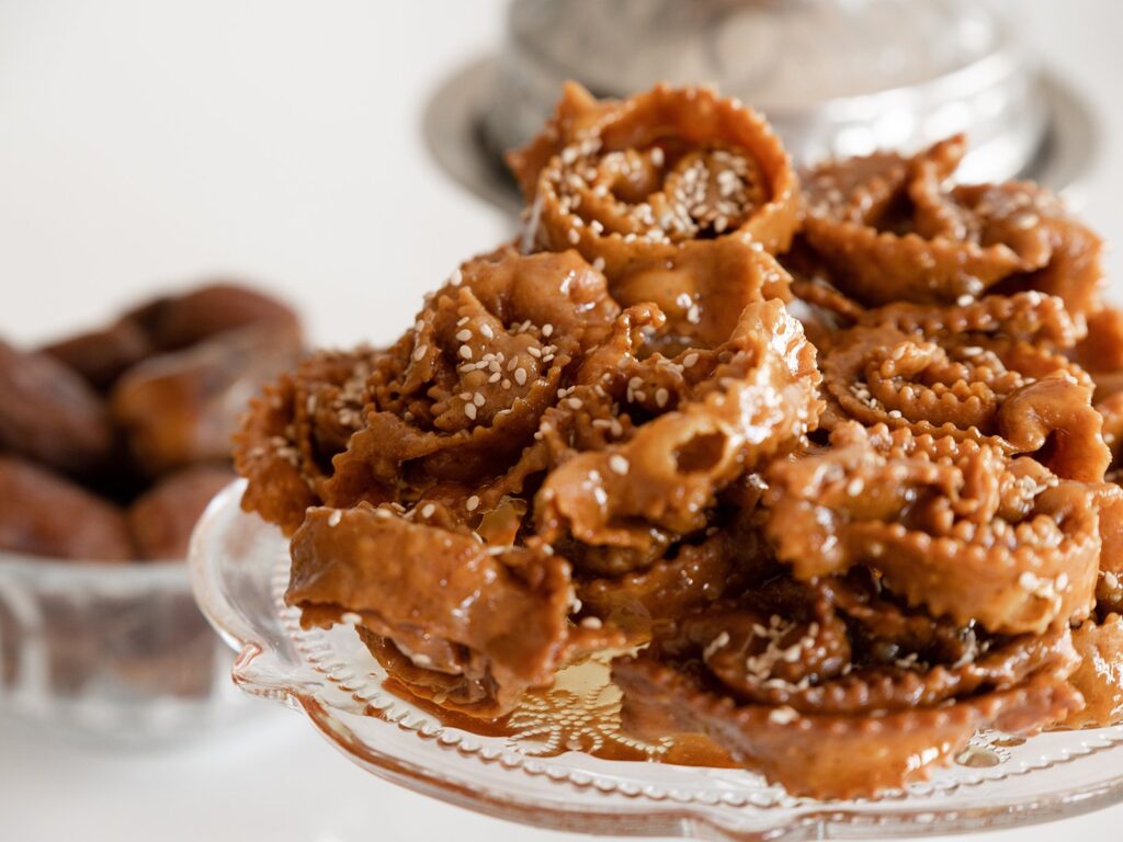 Crunchy Chebakia, Moroccan sesame cookies, piled on a glass plate.