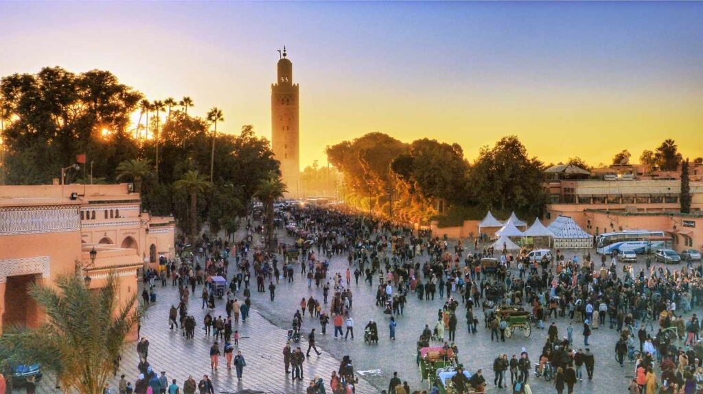 Marrakech Jamaa Elfna Square at sunset with the Koutobia Mosque in the horizon