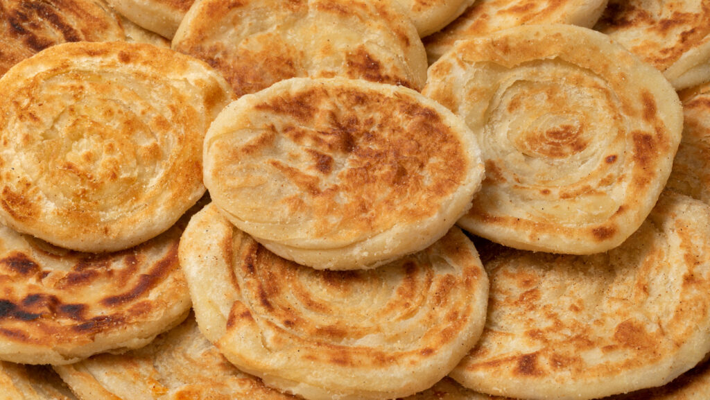Close-up of a pile of golden Meloui, Moroccan layered flatbread.