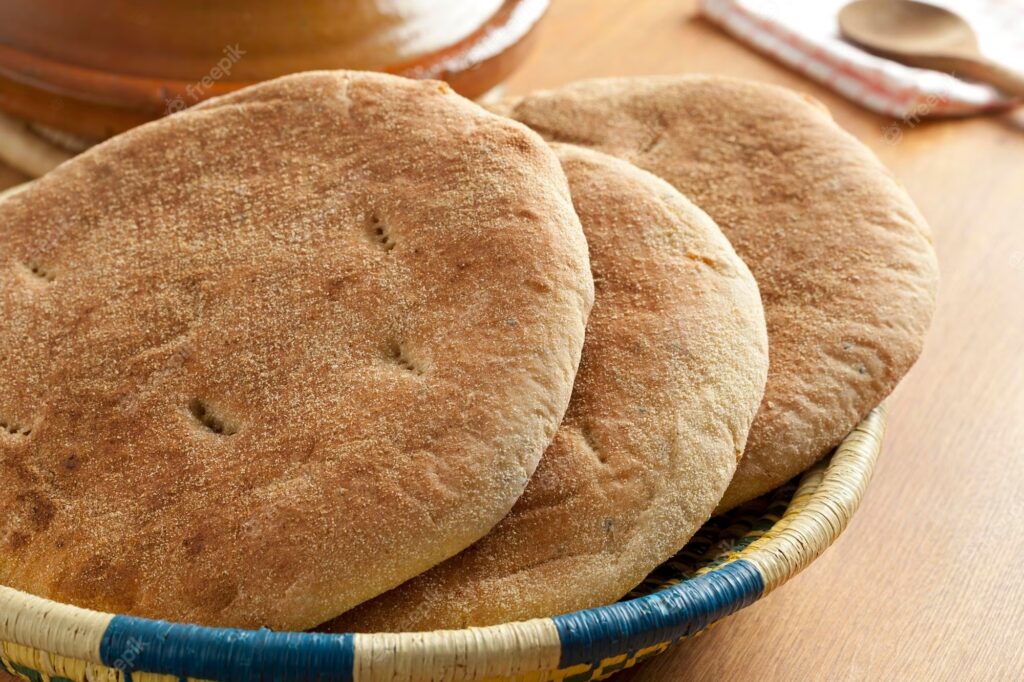 Freshly baked Moroccan Khobz bread in a traditional woven basket.