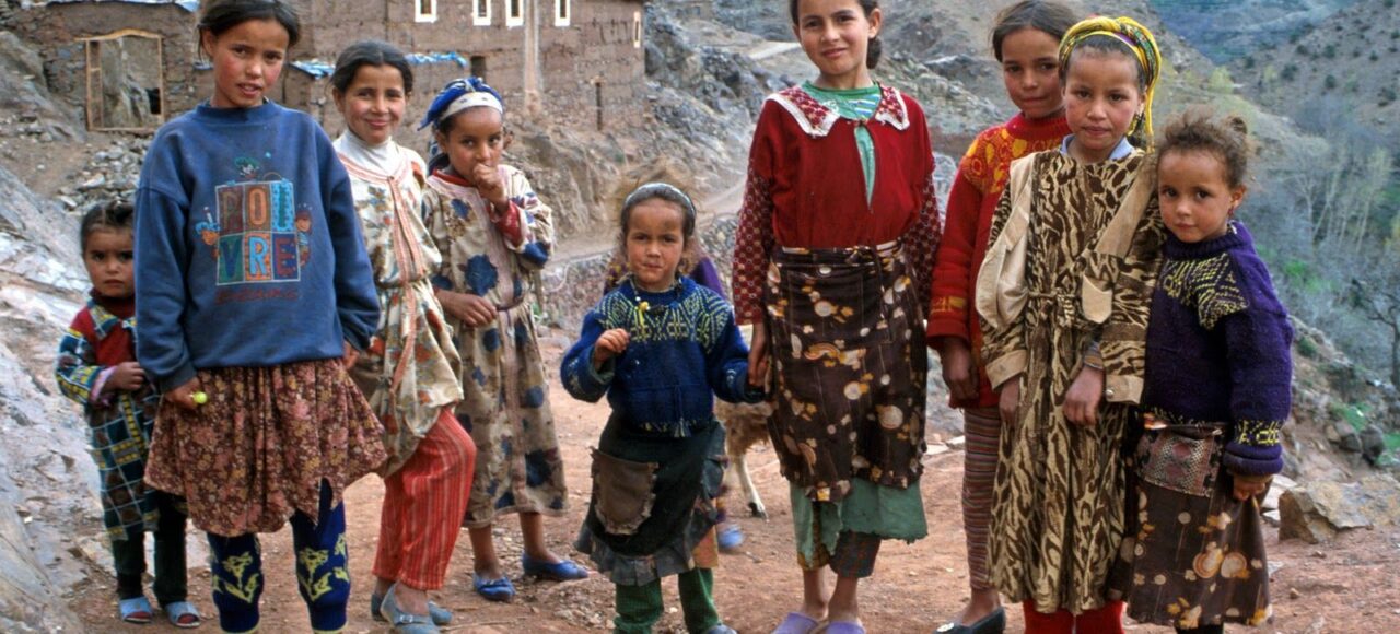 Group of children in traditional Moroccan attire in a mountain village, showcasing the vibrant cultural heritage.