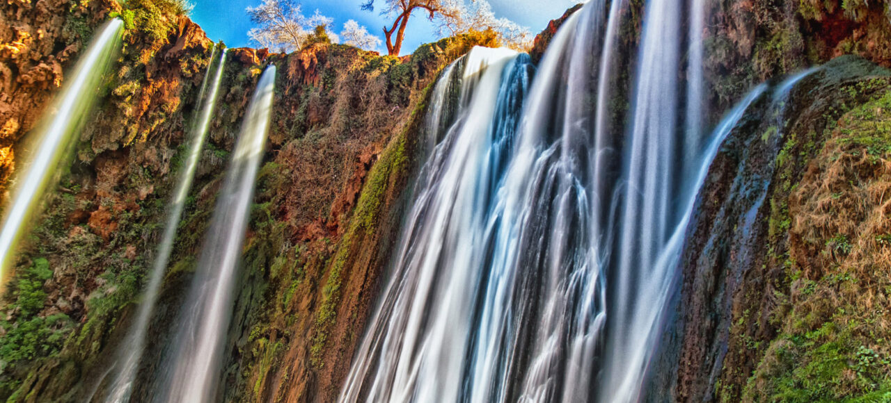 Majestic Ouzoud Waterfalls with vibrant cascades amidst lush Moroccan landscape