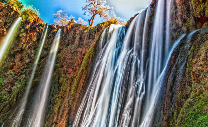 Majestic Ouzoud Waterfalls with vibrant cascades amidst lush Moroccan landscape