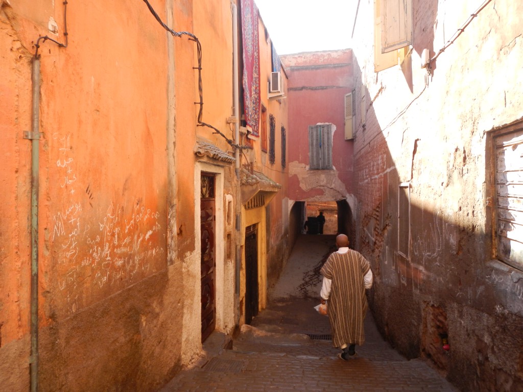 Man walking through a quiet alley in the Mellah, the historic Jewish quarter of Marrakech's Medina