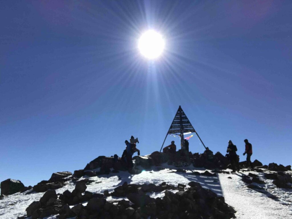Mount Toubkal summit with the sun shining in the backdrop