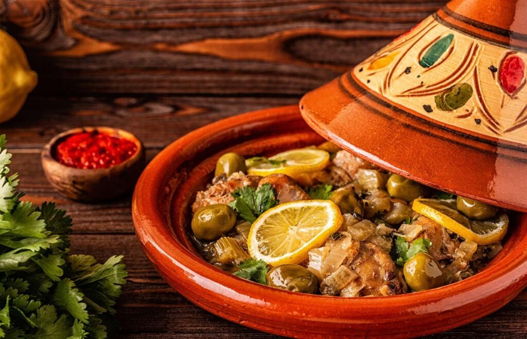 Traditional Moroccan Tagine with chicken, olives, and lemon slices, served in a decorative clay pot.