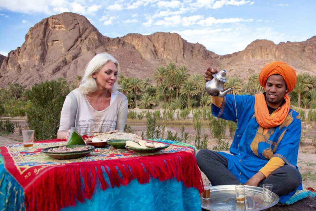 Berber nomad serving mint tea for a lady in Zagora oasis