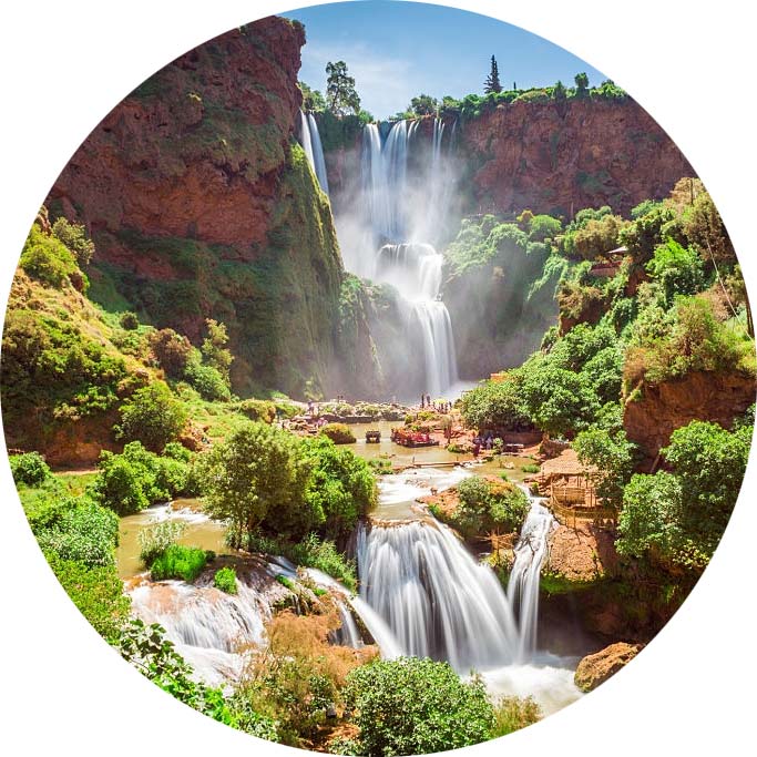 Circular frame capturing the breathtaking Ouzoud Waterfalls surrounded by lush foliage during a group Marrakech day trip.