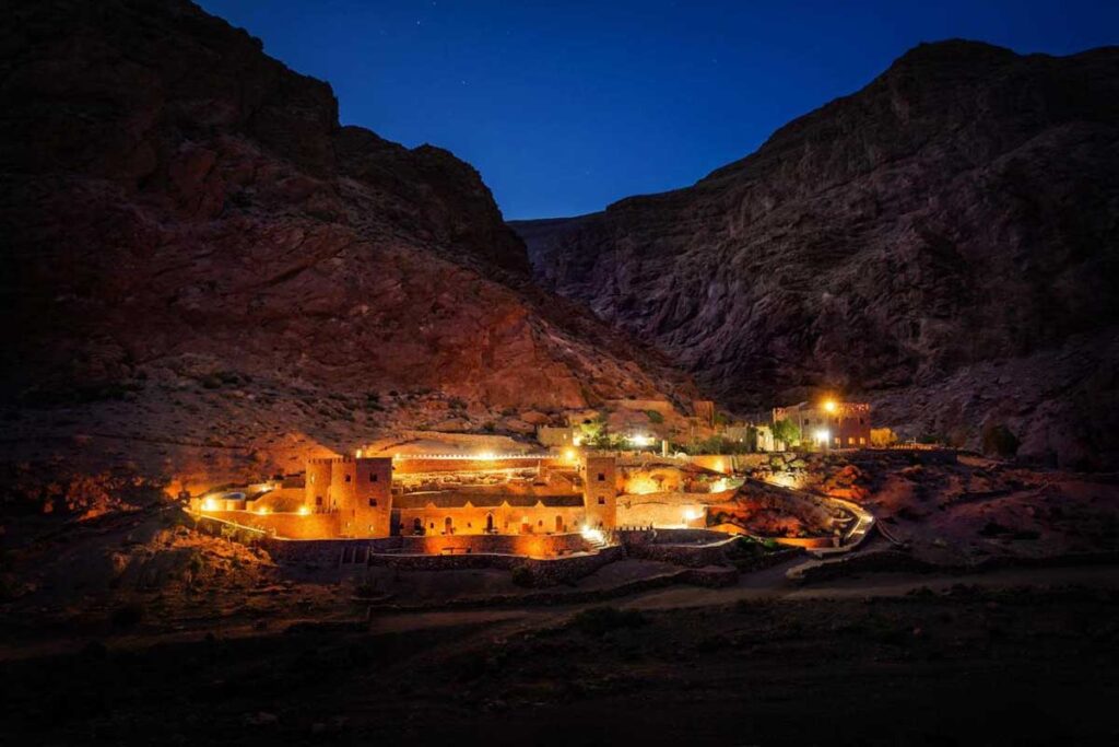 Kasbah-style eco-lodge glowing under starry sky inside Todgha Gorge