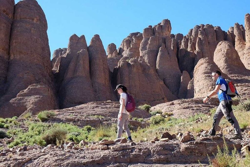 Hikers traverse Monkey Fingers rock spires in Dades Valley, a scenic day-trip from Todgha Gorge, Morocco