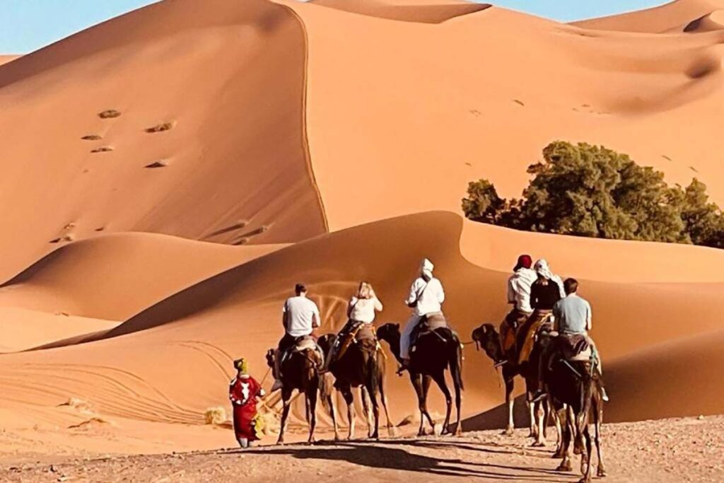 Sunrise breakfast in the dunes at a Merzouga luxury desert camp with Moroccan tea and fresh pastries