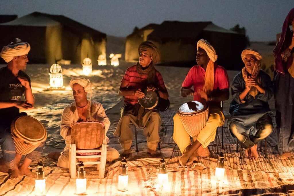 Nomad music performance by the campfire at night in a Merzouga luxury desert camp