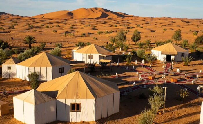 Luxury desert camp tents near Merzouga with panoramic views of the Erg Chebbi dunes in Morocco.